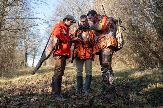 Group of hunters checking app.